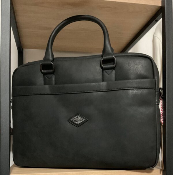 Photo prise de face du sac lee cooper couleur noir avec logo inscrit sur une plaque en métal chrome au milieu du sac
