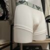 Photo prise de côté du boxer blanc armani avec la bande couleur vert menthe où le logo est inscrit