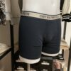 Photo prise de côté du boxer marine armani avec la bande couleur beige où le logo est inscrit