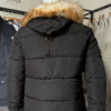 Photo prise de derrière du blouson couleur noir avec fourrure amovible de Frilivin. On aperçoit une languette pour régler le positionnement de la capuche.