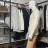 Photo prise de côté (photo complète) du pull torsadé au toucher cachemire écru de la marque Top Monday. On voit qu’il est associé avec le pantalon stretch beige sable de la marque Yves Enzo.