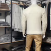Photo complète du pull torsadé au toucher cachemire écru (vue de dos) de la marque Top Monday. Il est porté avec le pantalon stretch beige sable de la marqu Yves Enzo.