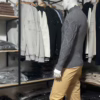 Photo prise de côté (photo complète) du pull torsadé au toucher cachemire gris de la marque Top Monday. On voit qu’il est associé avec le pantalon stretch beige sable de la marque Yves Enzo.