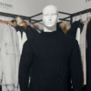 Photo du pull torsadé au toucher cachemire noir de la marque Top Monday, prise de face. On aperçoit le pantalon stretch beige sable de la marque Yves Enzo.