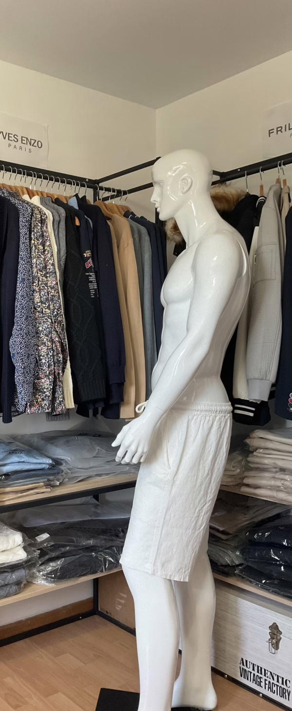 Vue de côté, le tombé du bermuda blanc Kenzarro révèle la fluidité du tissu coton-lin, qui bouge naturellement avec le corps. Sa couleur claire accentue la légèreté du modèle, tandis que la longueur mi-cuisse et la coupe droite assurent une allure décontractée mais soignée. Le cordon de serrage ton sur ton reste discret, renforçant l’aspect minimaliste et élégant du vêtement. Une pièce estivale pensée pour conjuguer confort et style sous le soleil.