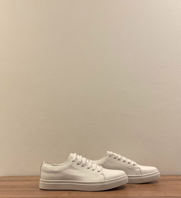 De côté, les sneakers Riveleft révèlent un profil équilibré et élégant, avec une semelle légèrement surélevée qui apporte du confort et de la structure. Le cuir lisse blanc donne une impression de pureté et de sophistication, tout en offrant une grande polyvalence. Ce modèle incarne le parfait compromis entre style urbain et sobriété chic.
