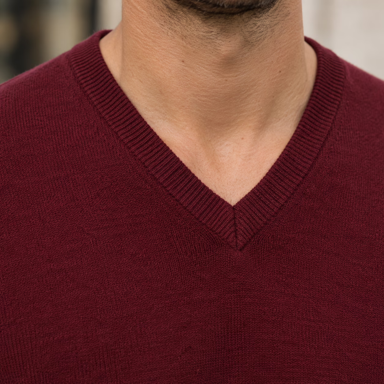 Gros plan sur le col V et la texture riche d'un pull en cachemire bordeaux "five ever".