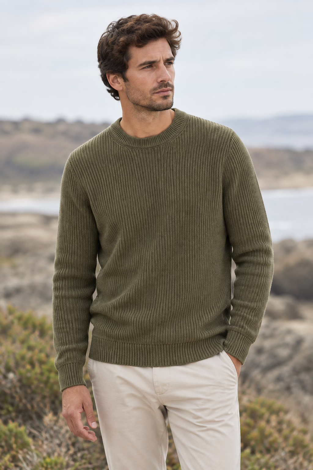 Pull Five Ever homme en maille côtelée vert olive, col rond, porté par un mannequin de face trois quarts dans un paysage côtier.