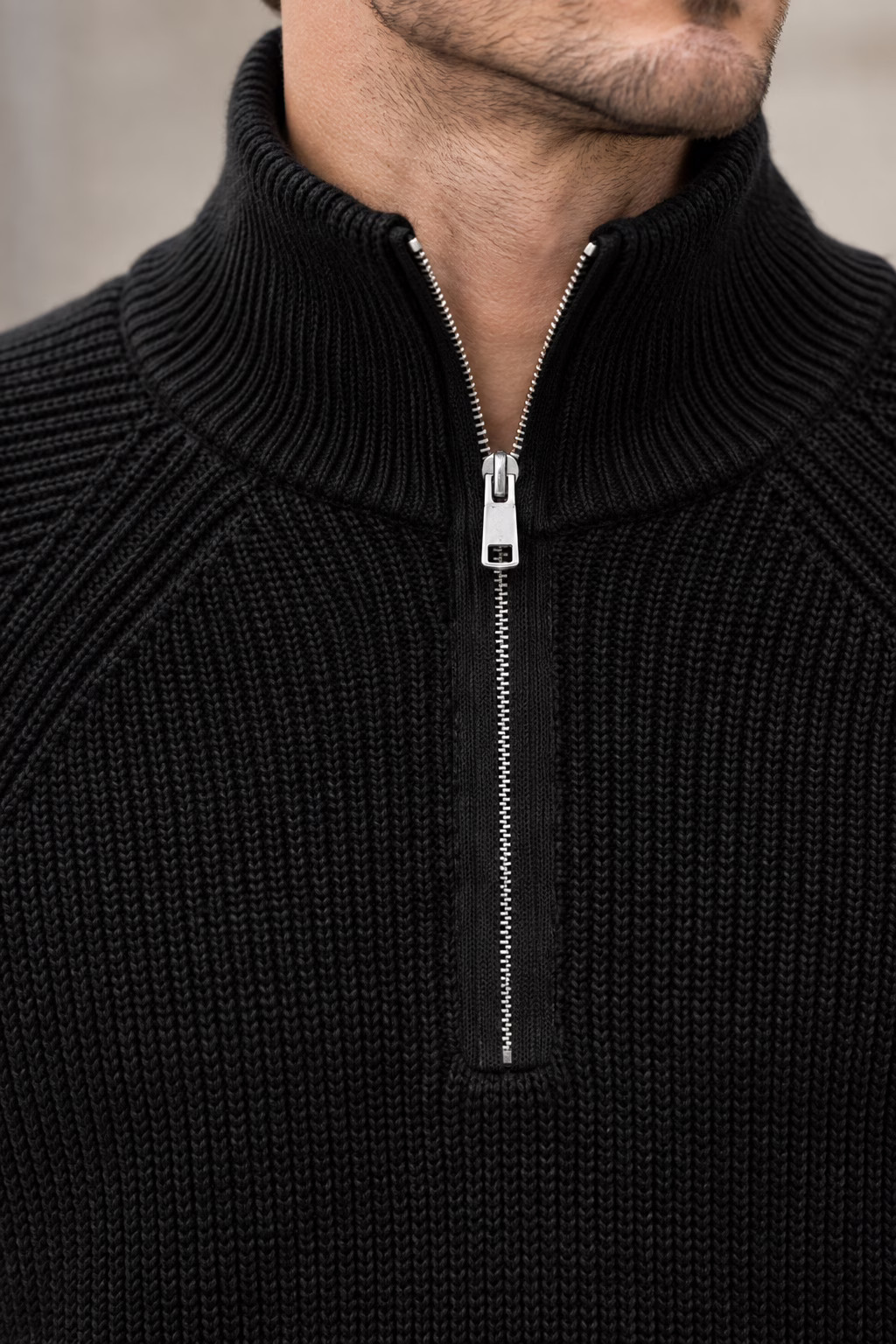 Gros plan sur le col zippé métallique du pull camionneur noir Five Ever.