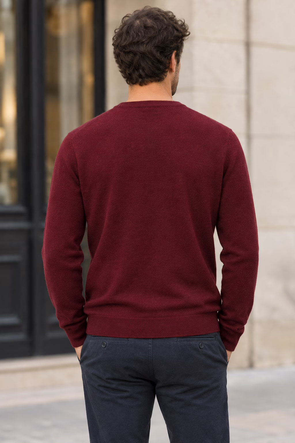 Vue de dos d'un homme portant le pull col V en cachemire bordeaux "five ever", posant en extérieur.