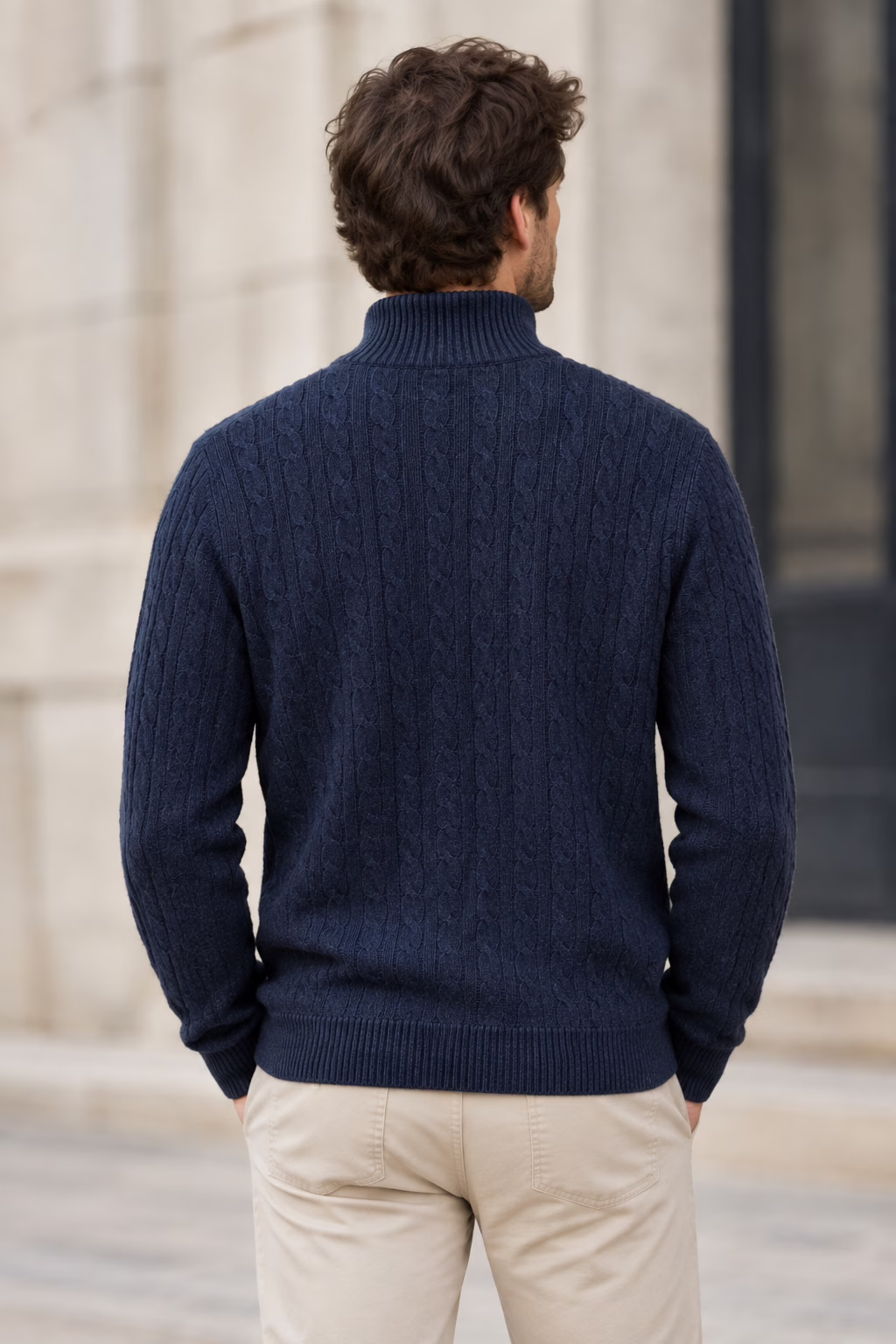 Vue de dos du pull Five Ever en maille torsadée bleu marine pour homme, col zippé et finition côtelée, devant un mur de pierre.